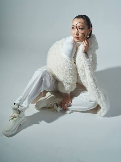 Pale studio fashion portrait with sculptural styling